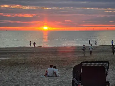 a group of people on the beach at sunset at Blue Wave in Egmond aan Zee