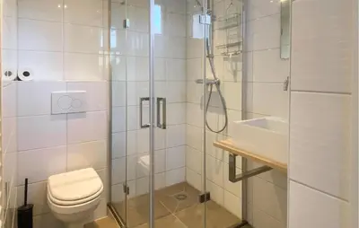 a bathroom with a shower and a toilet and a sink at Klein Maar Fijn in Bergen