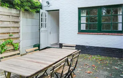 a wooden table and chairs in front of a house at Klein Maar Fijn in Bergen