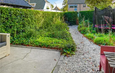 a garden with a hedge and a walkway at Klein Maar Fijn in Bergen