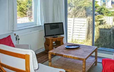 a living room with a table and a tv at Pimpernel2 in Bergen aan Zee