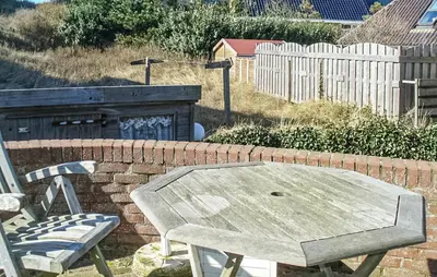 a picnic table and two chairs and a brick wall at Pimpernel2 in Bergen aan Zee