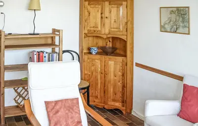 a living room with a chair and a book shelf at Pimpernel2 in Bergen aan Zee