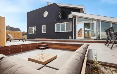 a black house on a roof with a patio at Villa By The Sea in Bergen aan Zee