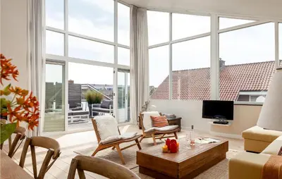 a living room with large windows and a tv at Villa By The Sea in Bergen aan Zee