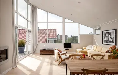 a living room with large windows and a couch at Villa By The Sea in Bergen aan Zee