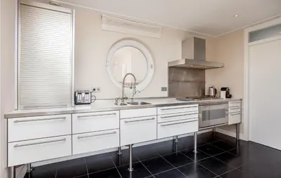 a kitchen with white cabinets and a sink at Villa By The Sea in Bergen aan Zee