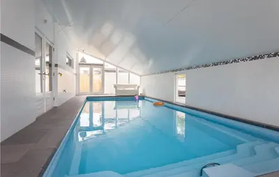 a large swimming pool in a white room with at Villa By The Sea in Bergen aan Zee