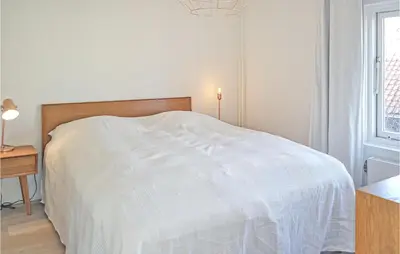 a bedroom with a white bed and a desk and a window at Nautilus 1 in Bergen aan Zee