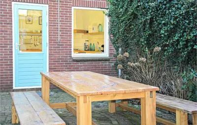a wooden table and benches in front of a building at Nautilus 1 in Bergen aan Zee