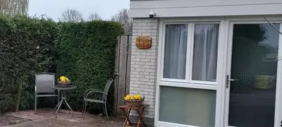 a door of a house with a table and a chair at Studio Dajan in Almere