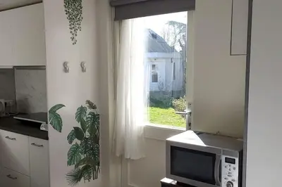 a kitchen with a microwave and a window at Studio Dajan in Almere