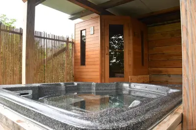 a hot tub on the outside of a cabin at Farmhouse, Jacuzzi, Sauna, BBQ grill & Garden, Sleeps 24 in Kockengen