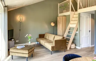 a living room with a couch and a staircase at Lovely Home In Oostwoud With Wifi in Oostwoud