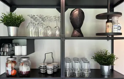 a shelf filled with glass jars and potted plants at Lovely Home In Oostwoud With Wifi in Oostwoud