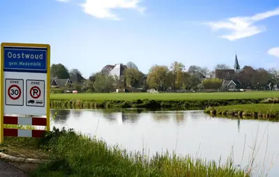 a sign on the side of a river next to a field at Lovely Home In Oostwoud With Wifi in Oostwoud