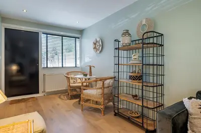 a living room with a book shelf and a table at SATORI LODGE near the Dunes & the Beach in Zandvoort