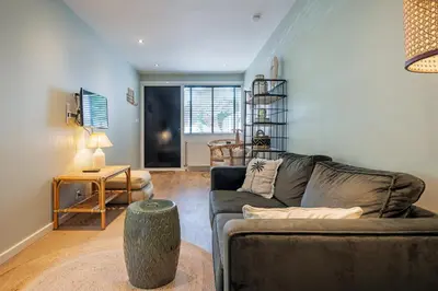 a living room with a couch and a table at SATORI LODGE near the Dunes & the Beach in Zandvoort