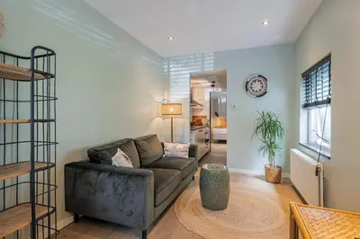 a living room with a couch and a table at SATORI LODGE near the Dunes & the Beach in Zandvoort