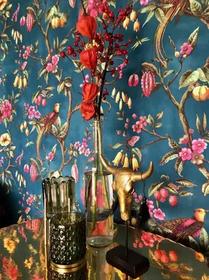 a table with a vase with flowers in front of a wall at Life Contains Beautiful Things in Almere