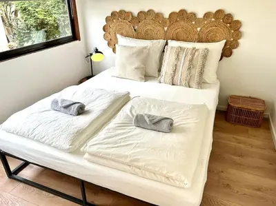 a large white bed with two towels on it at Cozy family house with spacious garden in the nature near Amsterdam in Vijfhuizen