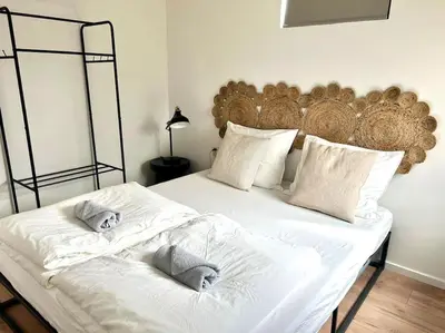 a bedroom with a large bed with white sheets at Cozy family house with spacious garden in the nature near Amsterdam in Vijfhuizen