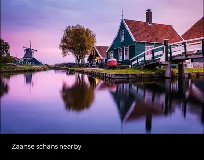 a house and a windmill next to a river at Cozy family house with spacious garden in the nature near Amsterdam in Vijfhuizen