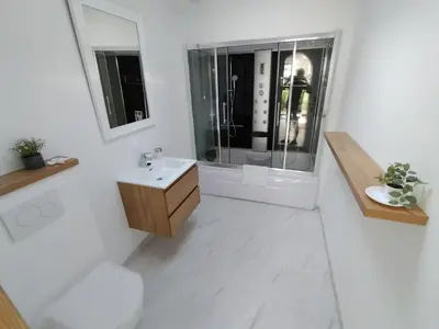 a white bathroom with a sink and a shower at Huisje Louis in Zandvoort