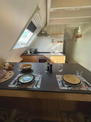 a kitchen with a table with plates and wine glasses at De hoftuin Ilpendam appartement in Ilpendam