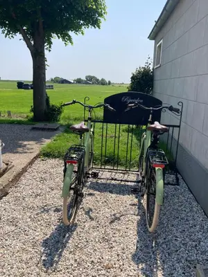 two bikes are parked next to a building at De hoftuin Ilpendam appartement in Ilpendam