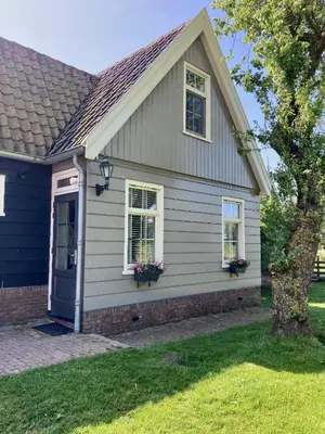 a house with two windows and a door at De hoftuin Ilpendam appartement in Ilpendam