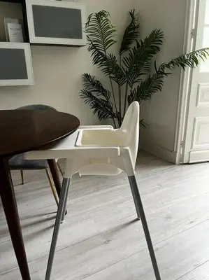 a white chair sitting next to a table with a plant at Luxury City Home Alkmaar nearby Amsterdam. in Alkmaar