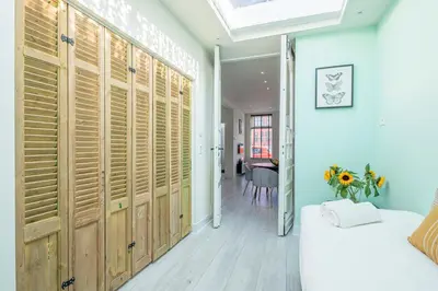 a bedroom with wooden doors and a bed and a table at Luxury City Home Alkmaar nearby Amsterdam. in Alkmaar