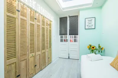 a bedroom with wooden doors and a bed and a window at Luxury City Home Alkmaar nearby Amsterdam. in Alkmaar