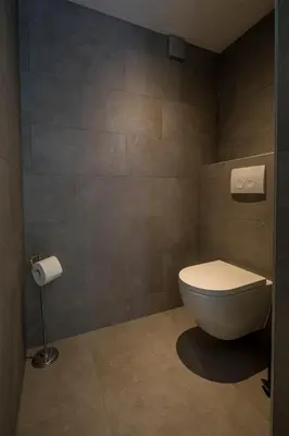 a bathroom with a toilet and a toilet paper dispenser at Luxury City Home Alkmaar nearby Amsterdam. in Alkmaar