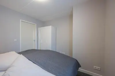 a white bedroom with a bed and a closet at Meerzicht 24 - Luxury family accommodation with beautiful lake side view in Uitgeest