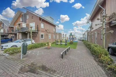 a brick street with buildings and a playground at Meerzicht 24 - Luxury family accommodation with beautiful lake side view in Uitgeest