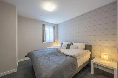 a small bedroom with a bed and a window at Meerzicht 24 - Luxury family accommodation with beautiful lake side view in Uitgeest