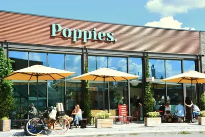 people sitting outside of a restaurant with umbrellas at Poppies in Amsterdam