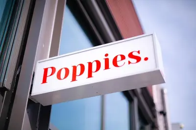 a sign on the side of a building with the word puppies at Poppies in Amsterdam