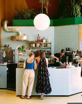 two women standing in a kitchen preparing food at Poppies in Amsterdam
