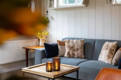 a living room with a blue couch and a table at De oude walnoot in Sint Pancras