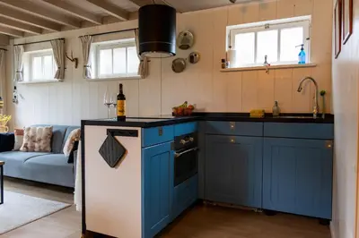 a kitchen with blue cabinets and a blue refrigerator at De oude walnoot in Sint Pancras