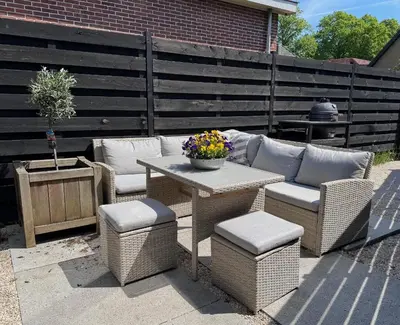 a patio with wicker furniture and a table and chairs at Modern guest house. in Bergen