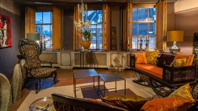 a living room with a couch and chairs and windows at De Ginkgo in het hart van Hoorn in Hoorn