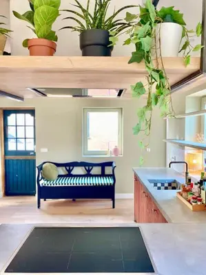 a living room with a couch and some plants at 30 steps to sand.. Light and spacious family villa in Zandvoort