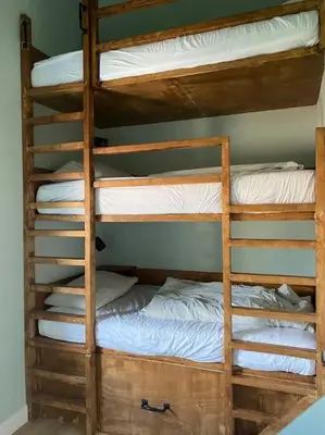 a couple of bunk beds with white sheets and pillows at 30 steps to sand.. Light and spacious family villa in Zandvoort
