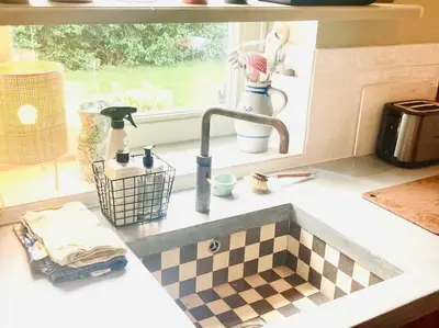 a kitchen counter with a sink and a window at 30 steps to sand.. Light and spacious family villa in Zandvoort