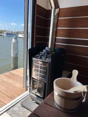 a stove sitting on a table next to a boat at Luxury Houseboat Liberdade with sauna and dinghy in Monnickendam