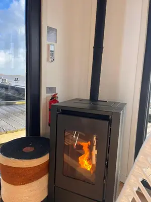 a fireplace in a room next to a window at Luxury Houseboat Liberdade with sauna and dinghy in Monnickendam